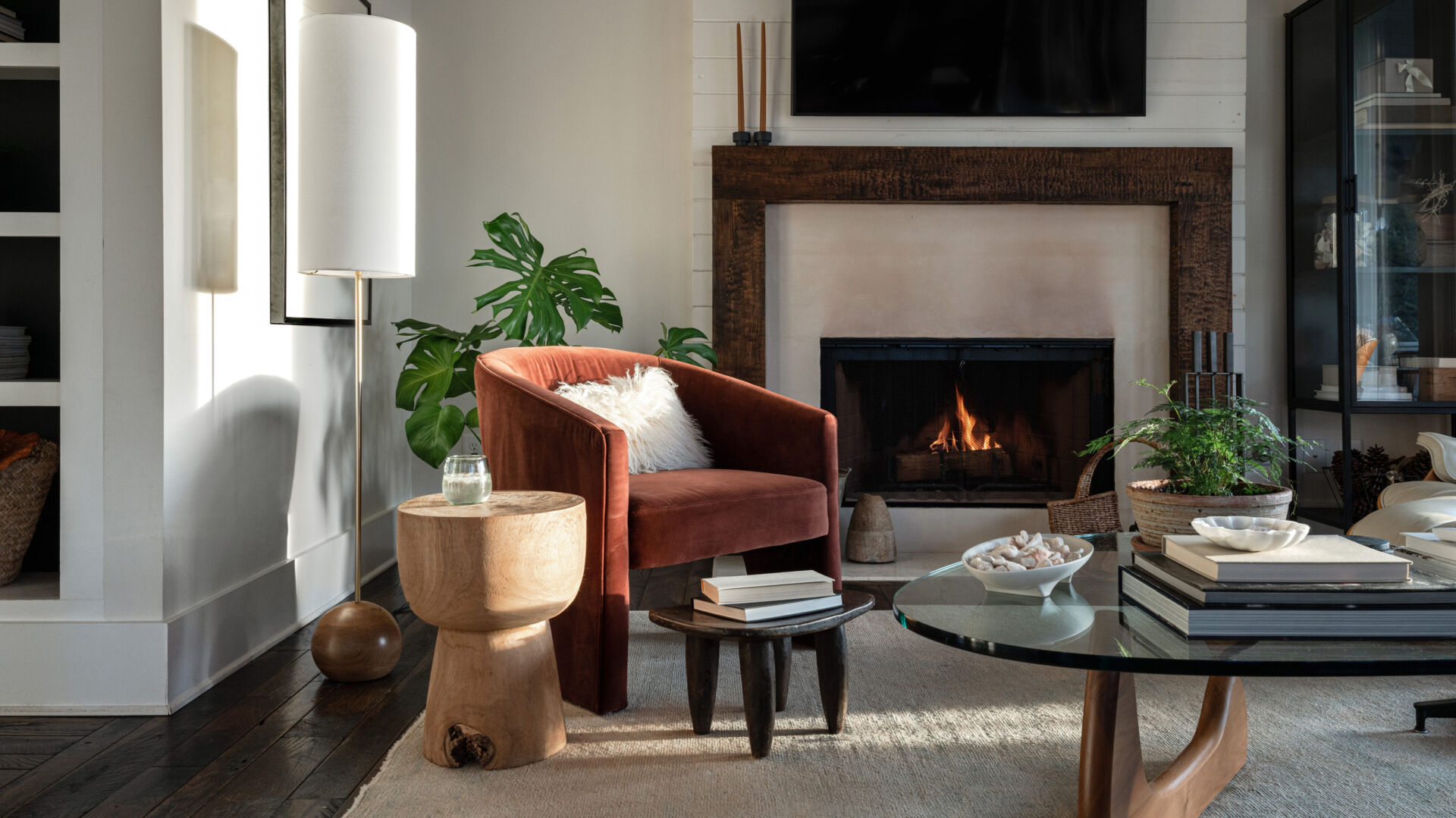 Living room with a lit fireplace, armchair, and coffee table