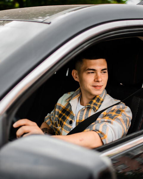 Hand reaching toward a car's touchscreen showing a garage door alert