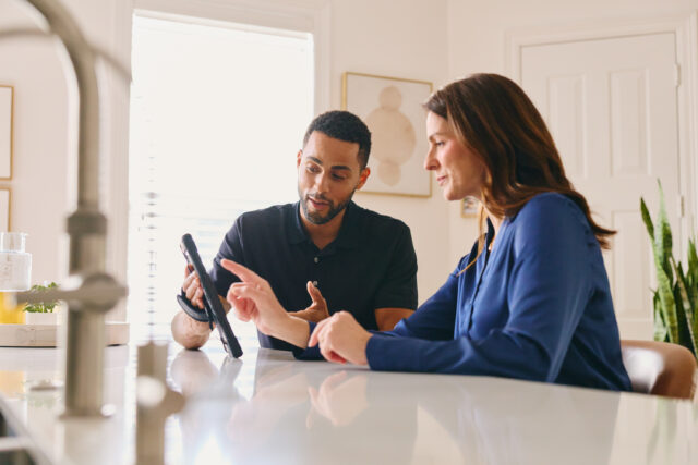 Two people reviewing a tablet together at a table